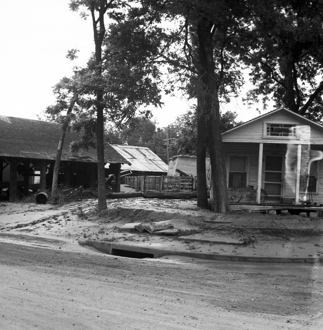 #33 Damaged houses and debris on road from flood, 1949