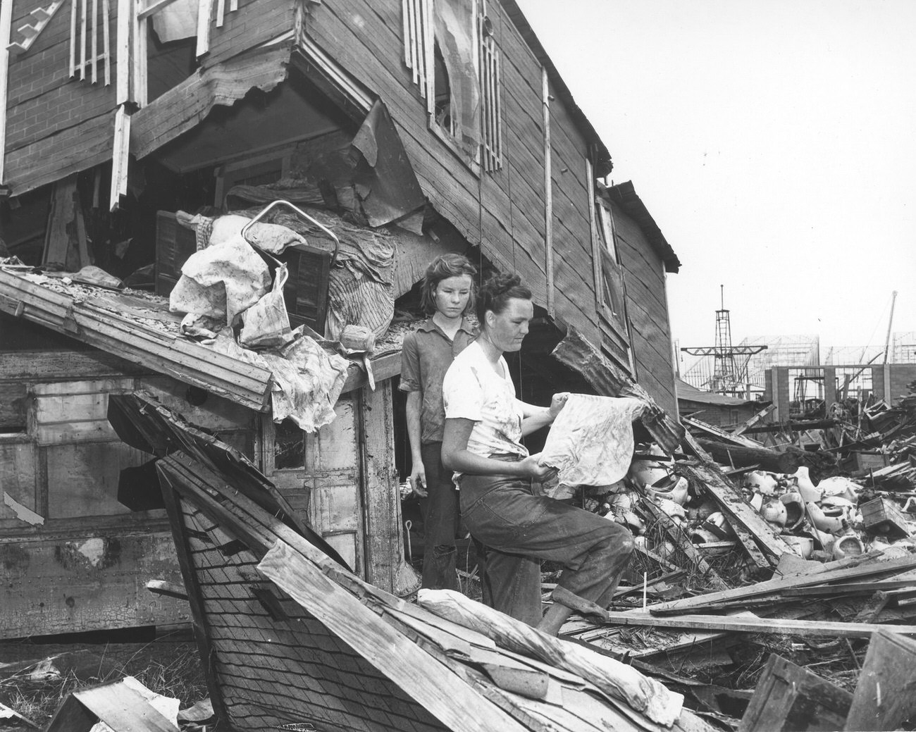 #68 Mother and daughter standing beside flood-destroyed home, Fort Worth, 1949.