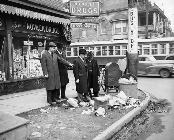 #128 Street cleaning team inspects a pile of garbage, 1940s