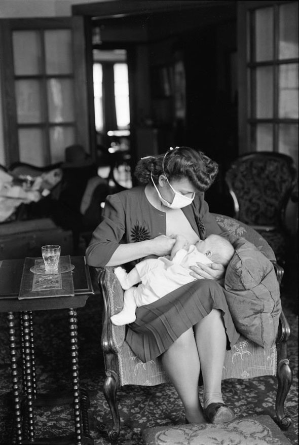#24 Visiting nurse feeds a baby, 1940s