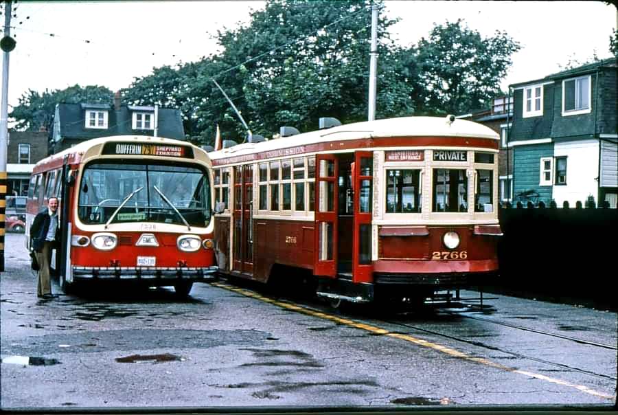 #133 A charter of TTC Peter Witt streetcar 2766, TTC 7528 is a 1972 General Motors Diesel Division T6H 5395 model bus and is doing Ontario Place express duty, 1976
