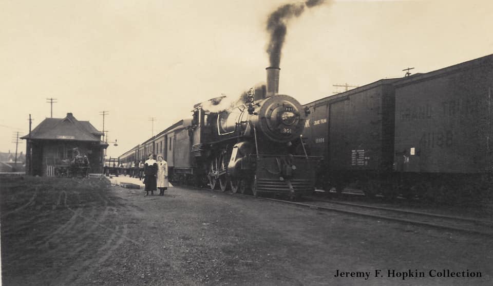 #82 Two ladies have their picture taken beside a train at the Grand Trunk Railway’s West Toronto station, 1910s.