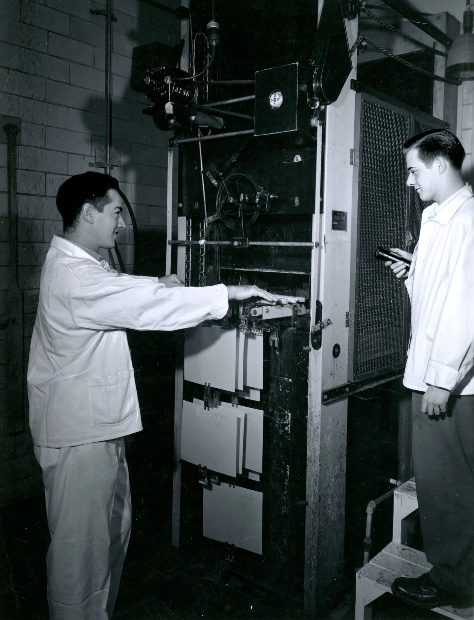 #141 Employees operating Pako Corp. Filmachine at the ‘Kodak Heights’ facility, 1950