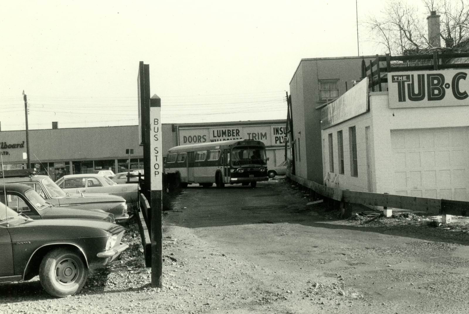 #100 Dawes bus coming west through laneway from dawes to Loblaws parking lot loop, 1960s