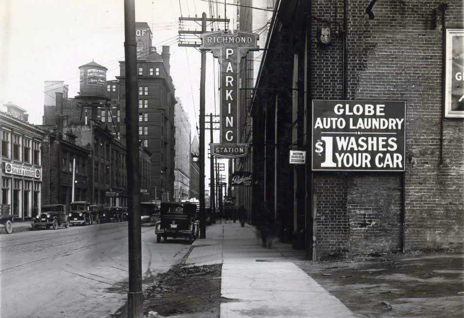 #15 Richmond Parking Station. An electric overhanging sign on a building located on the south side of Richmond Street West, west of Bay Street. View is looking east, 1920s
