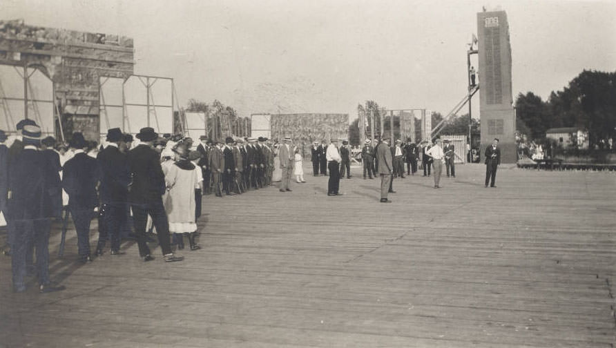 #10 Men, women and children in what may be a rehearsal are on the stage of the Pageant and Masque of St. Louis. Joseph Lindon Smith, director of the Masque, appears in shirt sleeves to the right of the photograph. More than 7500 St. Louis citizens volunteered for the event in Forest Park