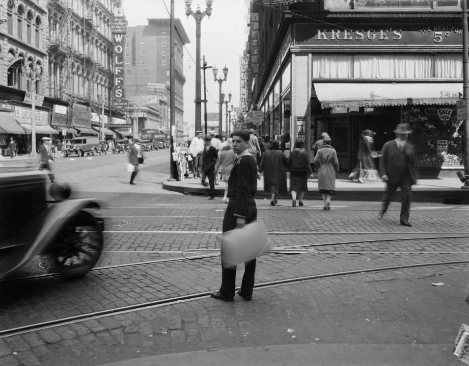 #34 View of a young man crossing Sixth street at Washington. Kresge’s is across the street, 1925