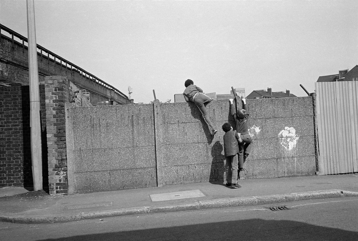 #14 Boys climbing over wall, Kennington, 1982