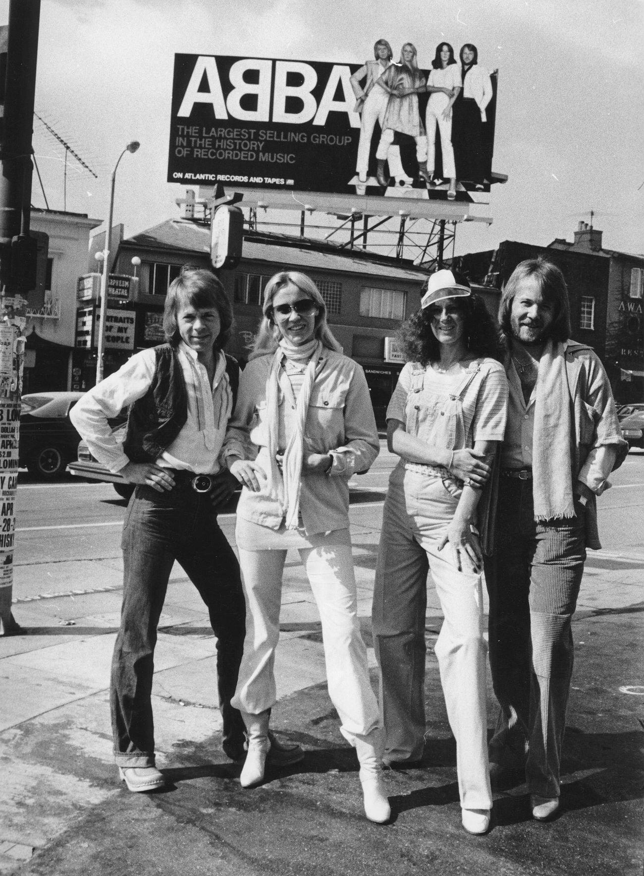 #13 ABBA, from left to right: Björn Ulvaeus; Agnetha Fältskog; Anni-Frid Lyngstad and Benny Andersson in front of a 7 high Poster of themselves in Los Angeles, 1978