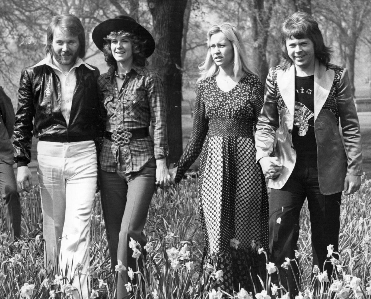 #37 Abba, winners of the 1974 Eurovision Song Contest at Brighton, strolling hand in hand amongst the daffodils in Hyde Park, London.
