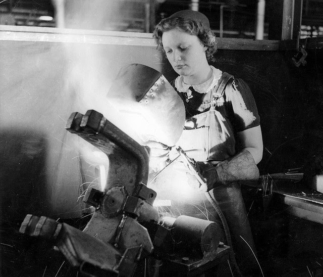 #11 A young woman arc welding part of an anti-tank gun in a munitions factory in South Australia.