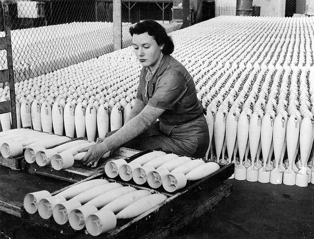 #13 A woman stacking practice bombs before transit to the explosives filling factory in South Australia.