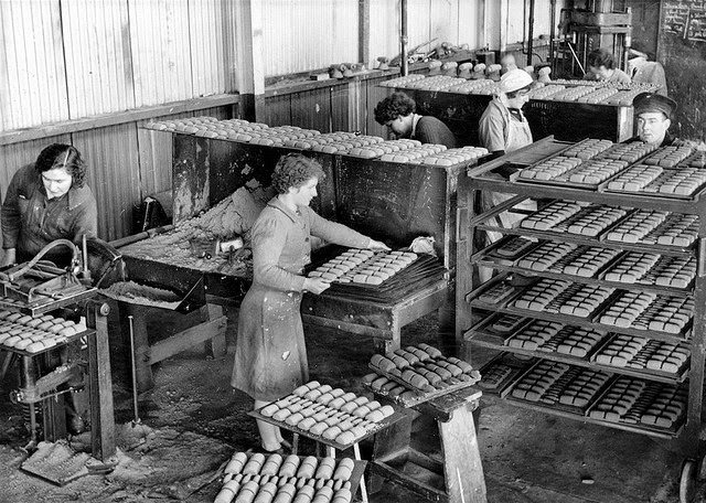 #19 Women working in a munitions factory preparing sand cores for practice bomb bodies.