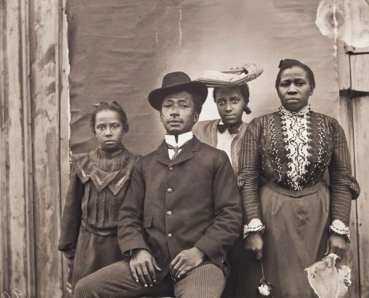 #2 James J. and Jennie Bradley Johnson Family. James J. Johnson, of Nipmuc, Narragansett, and African American descent, and Jennie Bradley Johnson, a migrant from Charleston, South Carolina, pose with their daughters Jennie and May.