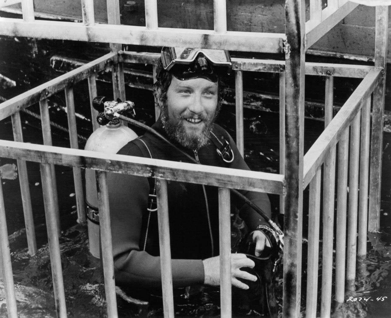 Richard Dreyfuss is lowered into the water in a diving cage in a scene from the film ‘Jaws’, 1975.