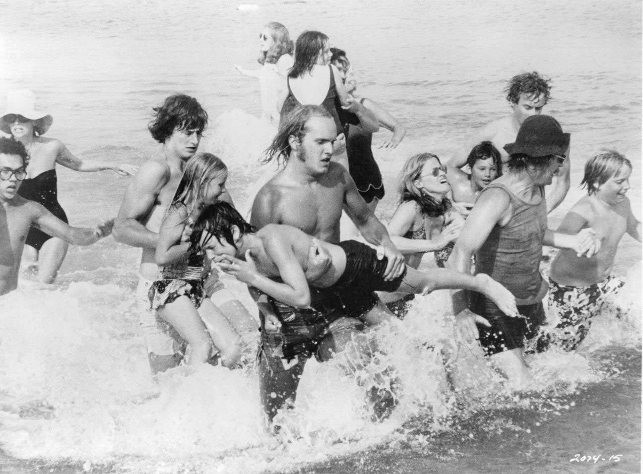 A group of actors are running out of the ocean in a panick in a scene from the film ‘Jaws’, 1975.