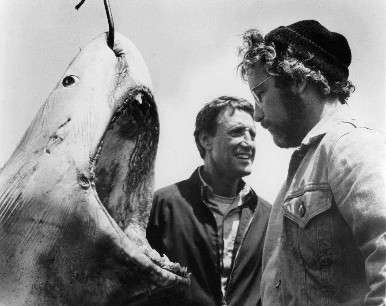 Roy Scheider and Richard Dreyfuss stand next to a giant man eating Great White Shark with a hook piercing through it in a scene from the film ‘Jaws’, 1975.