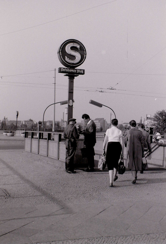 #44 The People’s Police checking documents of people entering Potsdamer Platz S-Bahn. Picture taken from West Berlin.
