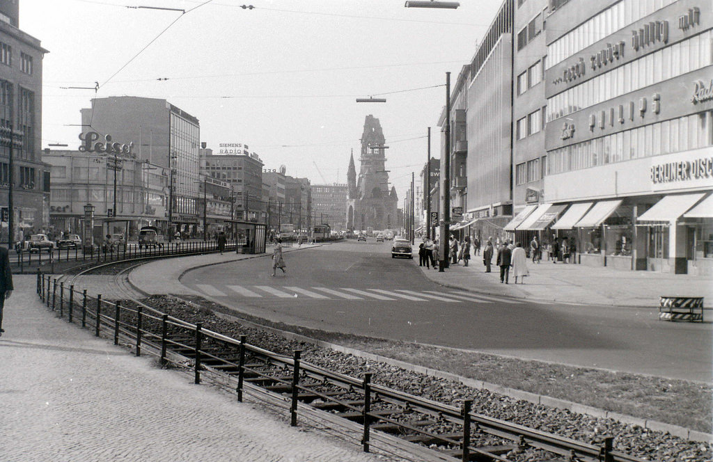 #50 Tauentzienstrasse meets Kurfuerstendamm at the ruin of the Kaiser Wilhelm memorial church, which can be seen in the distance. On the extreme left can be seen the edge of KaDeWe, the largest department store in mainland Europe.
