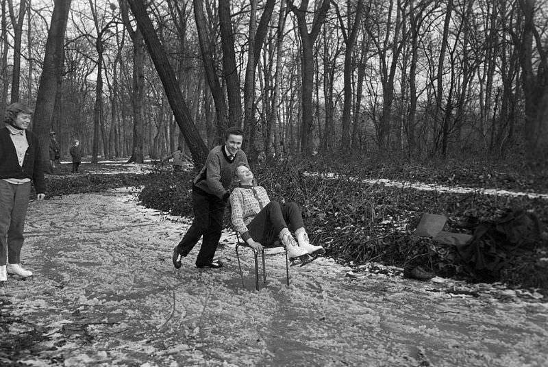 #16 A young man pushing his friend on a chair on the frozen lake.