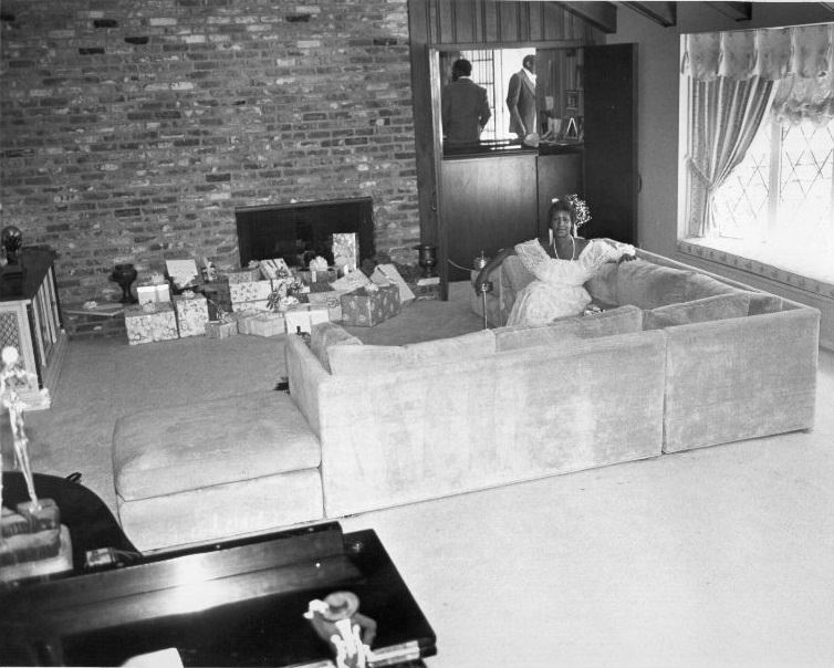 #95 Aretha Franklin with her Christmas presents at her Detroit home, 1980.