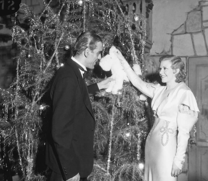 #31 Ginger Rogers chats with actor Boris Karloff next to a Christmas tree at a Hollywood charity gala, 1932.
