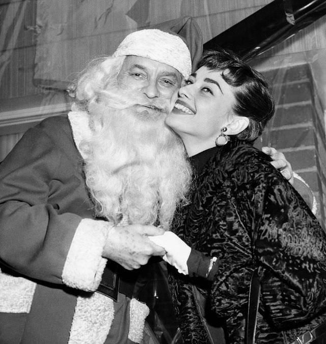 #87 Audrey Hepburn smiles with Santa at a charity event in New York City during the holidays, 1953.