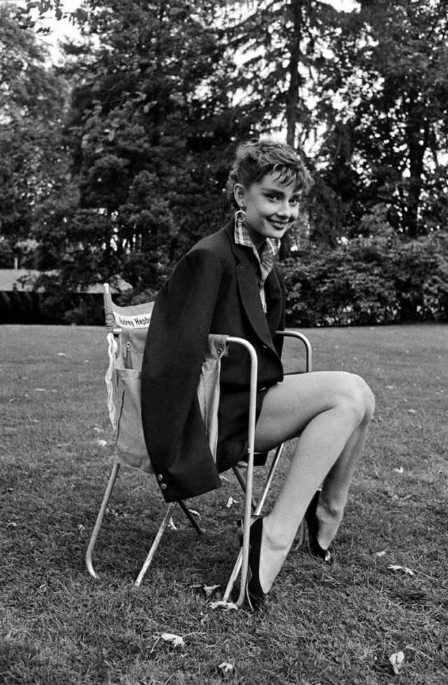 #17 Audrey Hepburn wearing Humphrey Bogart’s jacket takes a break on the set of ‘Sabrina’, 1954