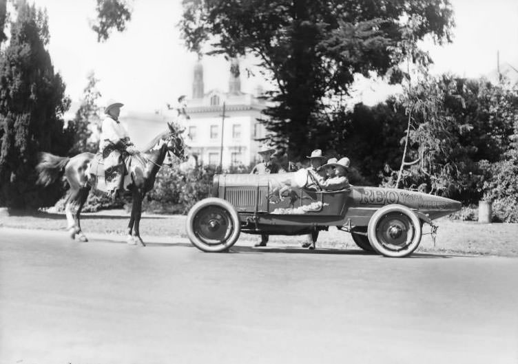 REO Motor Car Company “Pony Express” promotional race car pictured alongside a cowboy sitting on a horse in San Francisco’s Golden Gate Park, 1923