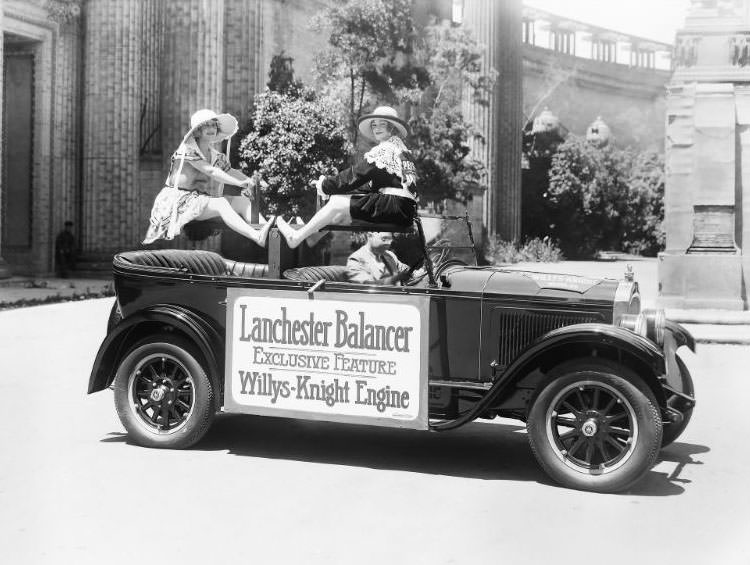 Two pretty girls balancing on a teeter-tooter inside a “Willy-Knight” convertible motor car promoting the “Lancaster Balancer” an exclusive feature of the Willys-Knight engine, 1925
