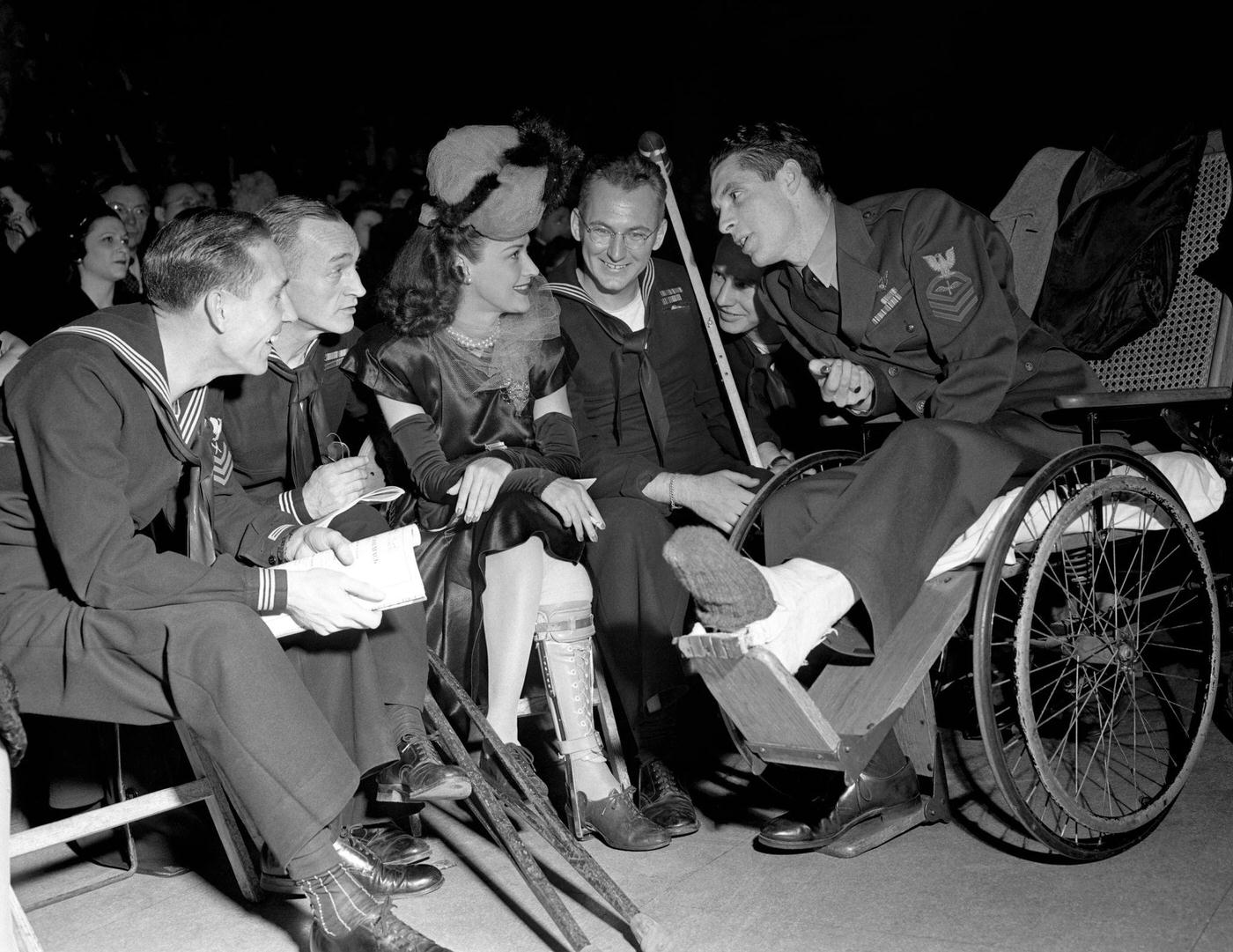 #5 Jane Froman sits and talks to Military personnel during the Newspaper Guild Ball on December 6, 1945 in New York