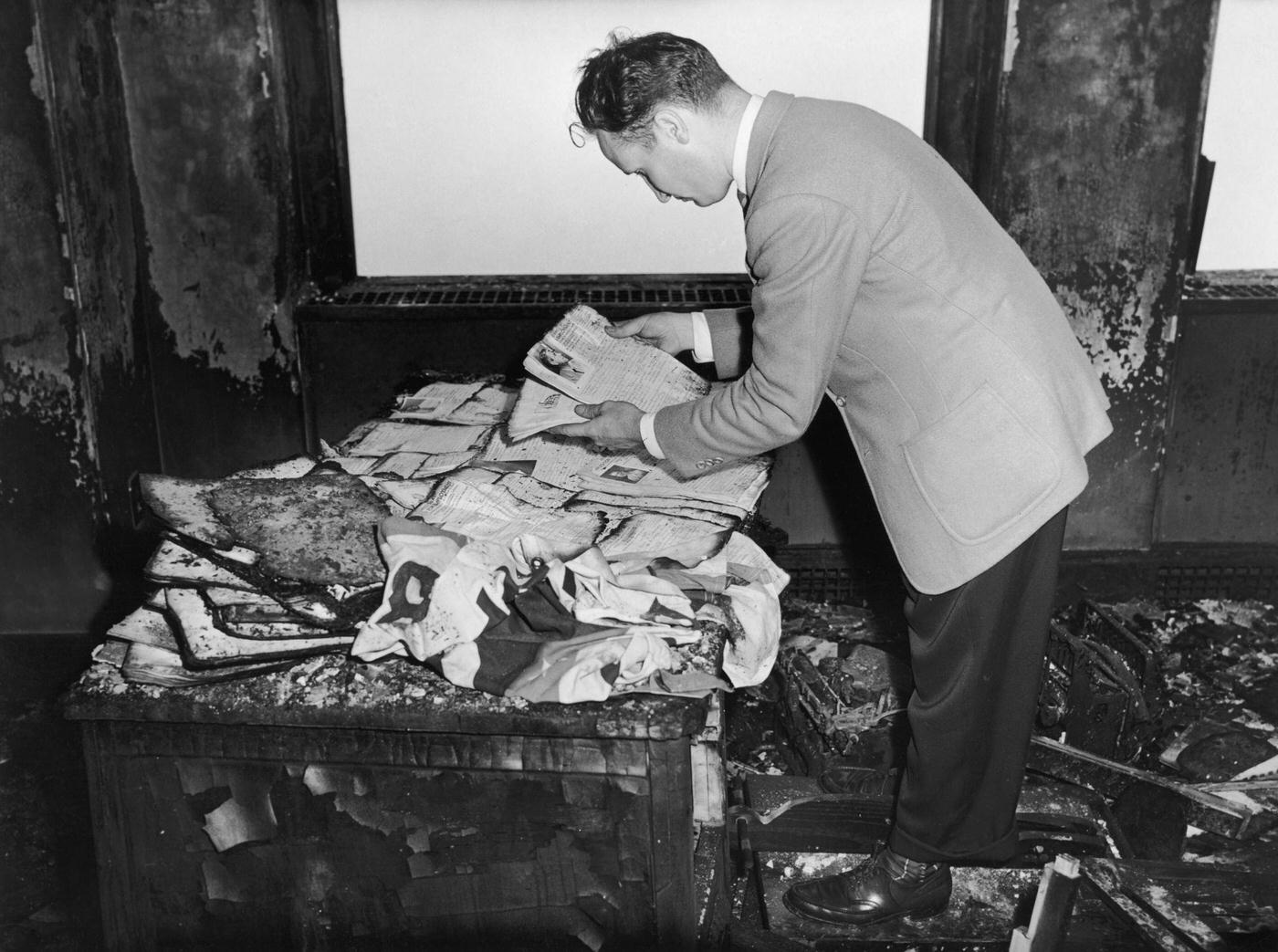 #9 A man examines charred documents in an office in the Empire State Building after a B-25 Mitchell bomber