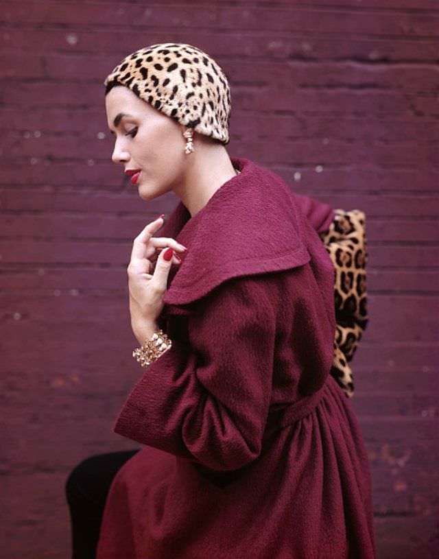 #11 Georgia Hamilton poses in a plum-colored coat designed by Pauline Trigere, jaguar hat skull cap by Mr. John, jaguar muff by Aaron Reiss, jewelry by Schlumberger, 1949