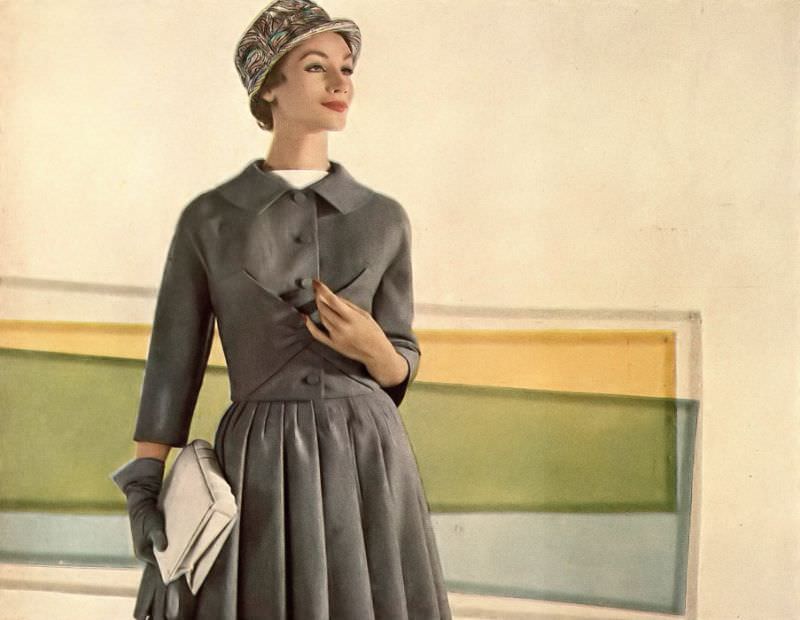 #11 Ruth Neumann Derujinsky in gray flannel suit, jacket is folded envelope-style at the waist, skirt is lined with organdie to billow out by Marquise, cloche by Emme, photo by Gleb Derujinsky, Harper’s Bazaar, February 1957