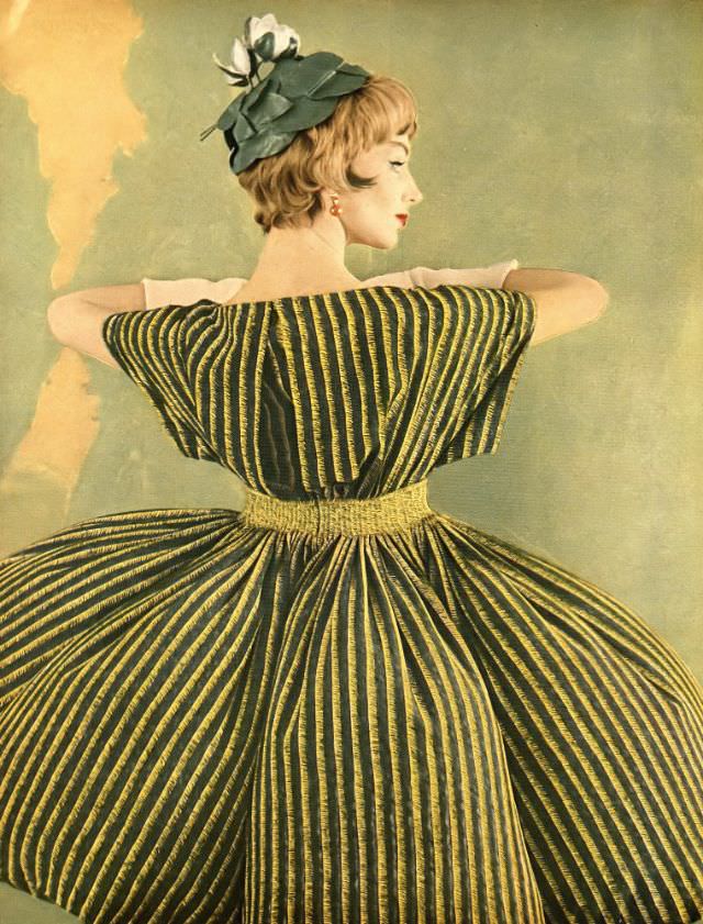 #26 Ruth Neumann Derujinsky in silk crêpe dinner dress of yellow and black stripes on green with wide kimono sleeves by Galanos, leafy green hat by Mr. Arnold, photo by Gleb Derujinsky, Harper’s Bazaar, April 1959