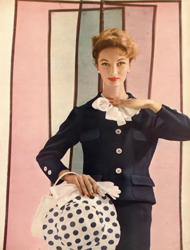 #8 Evelyn Tripp in navy blue suit with white blouse bowed at the collar, photo by Gleb Derujinsky, Harper’s Bazaar, February 1957