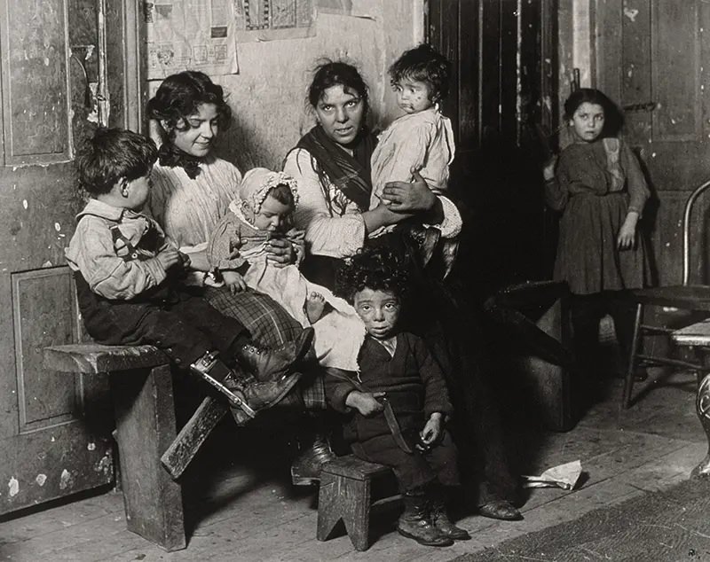 #33 Italian family sits for its portrait in Chicago tenement near Hull House, 1910.