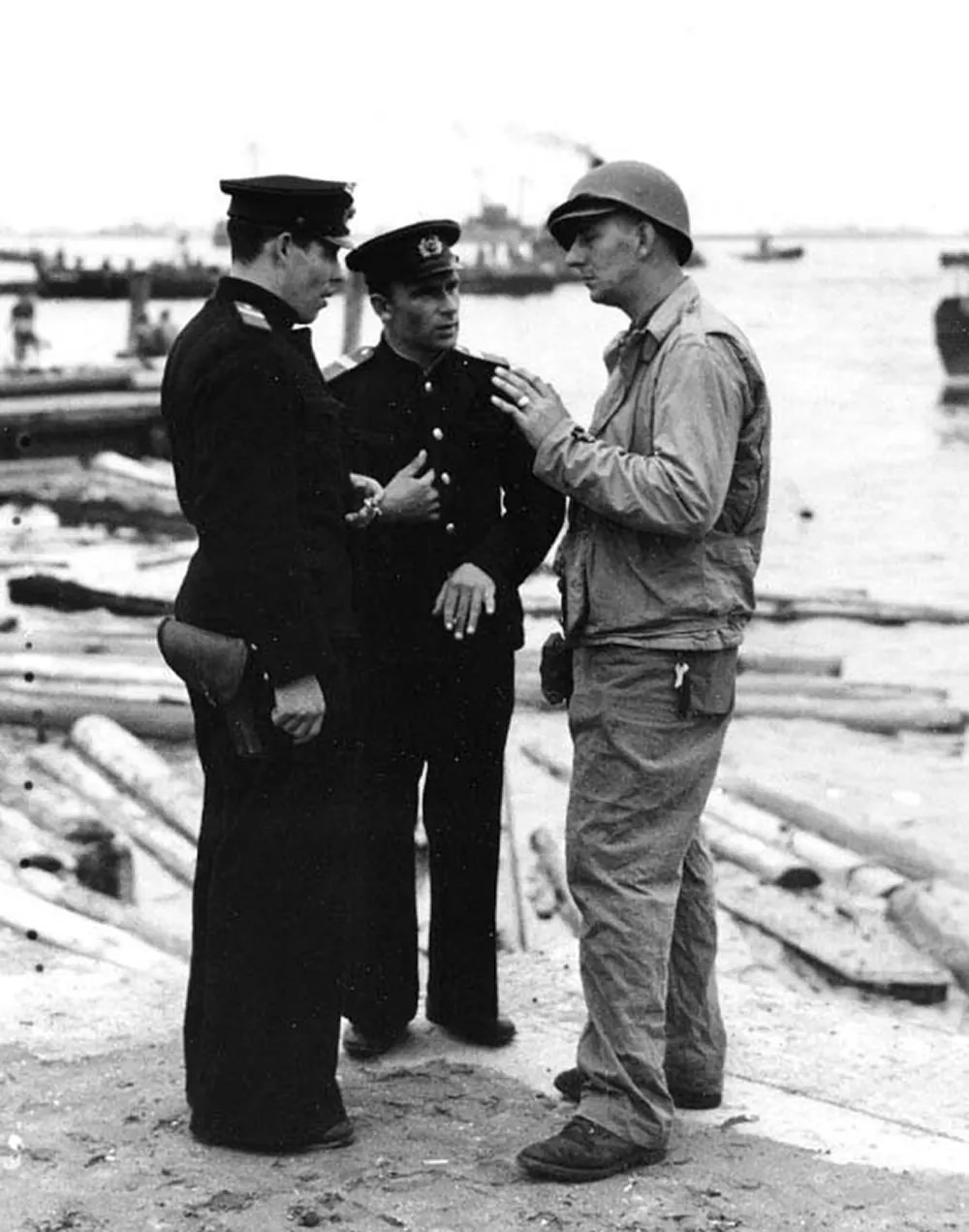 #10 Two Soviet Navy officers talking with a member of the boat group from USS Talladega (APA-208) on the beach at Yokohama, 2 September 1945.