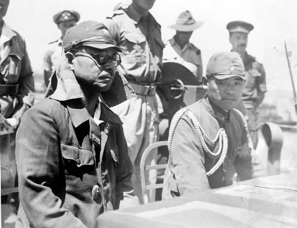 #21 Kaida Tatsuichi, commander of the Japanese 4th Tank Regiment, and his chief of staff Shoji Minoru listen to the terms of surrender on HMAS Moresby at Timor.