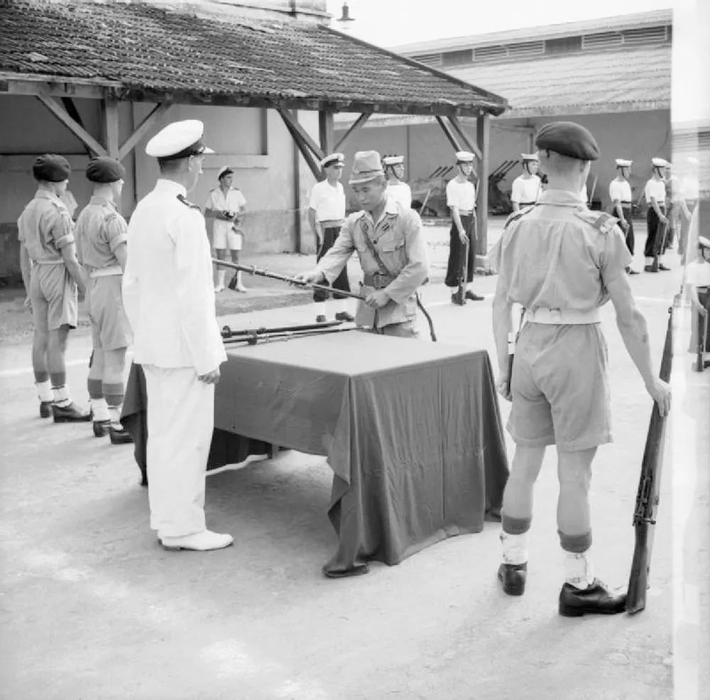 #23 A Japanese officer surrenders his sword to a British Lieutenant in a ceremony in Saigon, French Indochina.