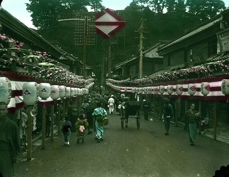 #1 Crowd-filled street lined with banners and lanterns.