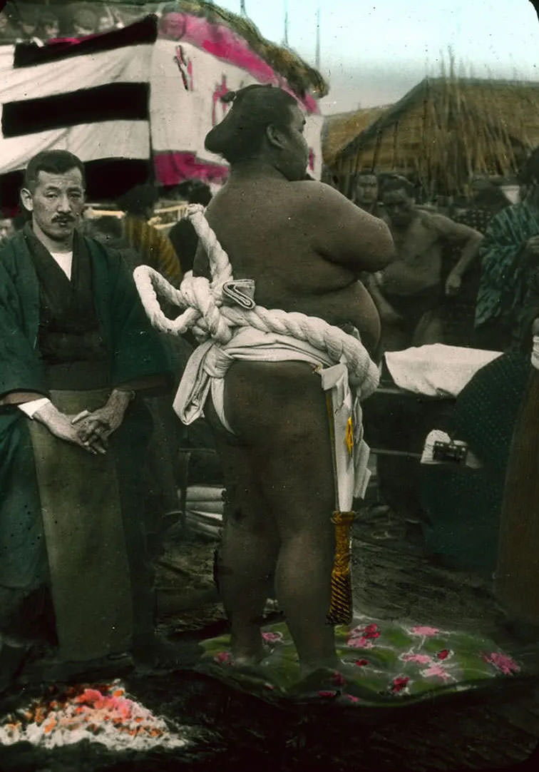 #15 Men preparing for sumo wrestling outdoors.