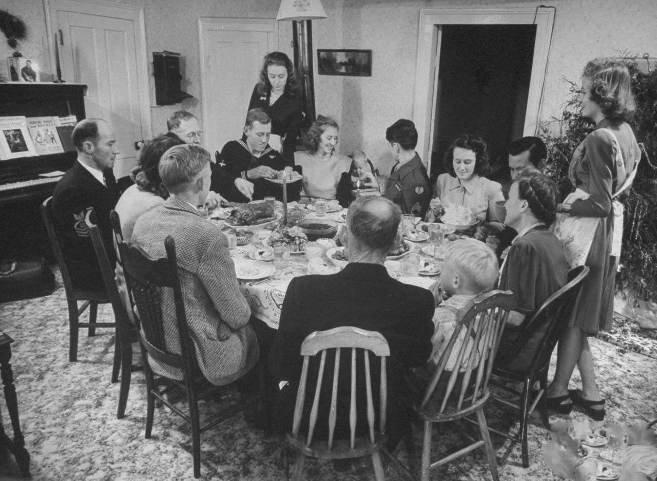 #14 James Ferdinand Irwin family sitting around table having Christmas dinner, their young men safely returned from WWII, (clockwise from L) Fred Andrews, Mr. Irwin, Jim, unidentified, Jeanne, Joe, Levern Love, Myra Lee, Jack, unidentified, Mrs. Irwin Scotty