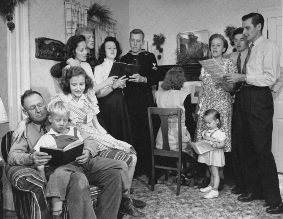 #9 James Ferdinand Irwin’s family singing carols at early family reunion Christmas celebration marking safe return of sons fr. WWII (L-R) Mr. Irwin, Scotty, Carolyn, Betty Roush, Jim, Myra Lee Love, Jack, Jeanne Haney, Mrs. Irwin, Jeff Haney, Levern Love, I.I. ris Beth Love.