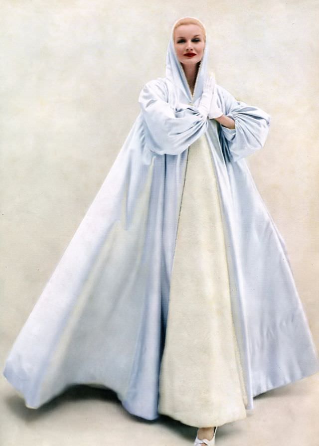 #13 Sunny Hartnett in a billowing hooded evening coat of ice blue satin by Grès, 1954
