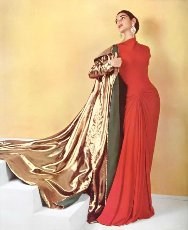 #14 Jacky Mazel in figure-hugging coral silk-jersey evening dress worn with gold lamé evening coat by Grès, chandelier earrings by Scémama, 1955