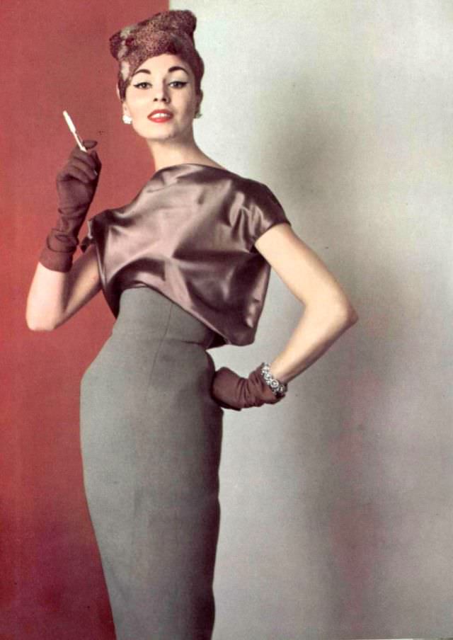 #18 Model in elegant understated gray wool dress with satin blouson bodice by Grès, hat by Svend, 1956