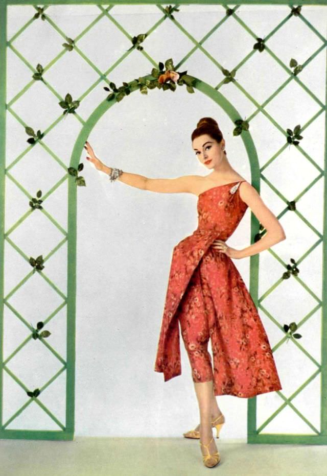 #23 Model in print silk taffeta dress, one-shoulder bodice and over-skirt is split in two panels by Grès, 1957