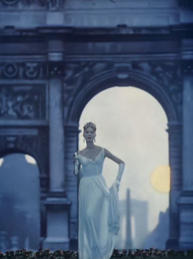 #24 Model in white crêpe gown flowing out of itself into pleats that follow the shape of the figure by Grès, Vogue, October 1, 1957