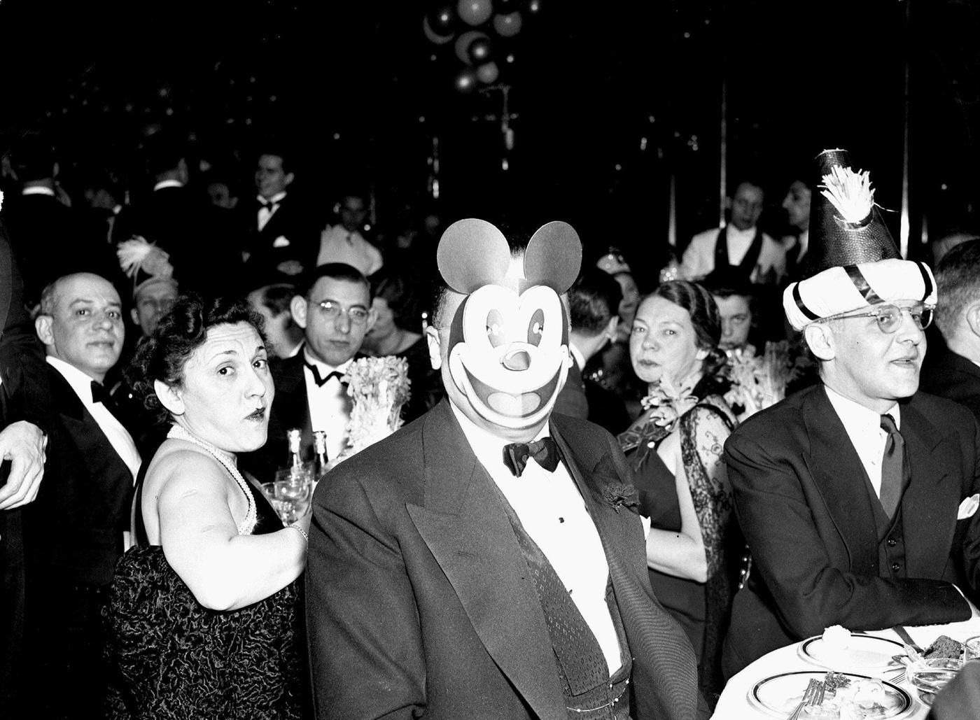FBI director J. Edgar Hoover wearing Mickey Mouse mask at New Year’s Eve party.